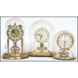 A group of vintage 20th century anniversary clocks to include a German Kundo glass domed clock