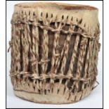 A vintage 20th century African tribal animal hide and hair drum with skin top and bottom stretched