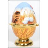 A Moorcroft painted enamel on copper trinket box in the form of an egg, decorated with chickens,