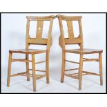 A pair of early to mid 20th century elm and beechwood chapel chairs with hymn book receptacles and