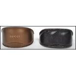 Two pairs of vintage Gucci sunglasses in original leather boxes with Gucci lettering to front.