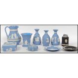A collection of Wedgwood jasper cameo ware to include a pair of vases, jug, pot and pin dishes.
