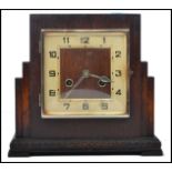A 1930's Art Deco mantel clock set within an oak square case with silvered chapter ring and inset