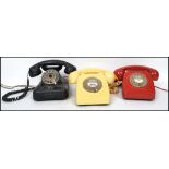 A group of three retro 20th century ring dial telephones, one red, one cream and one of black