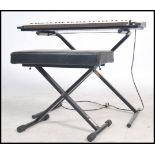 A retro 1970's Yamaha DX - 11 synthesizer / keyboard, with stand and matching stool. One key missing