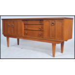 A 1970s Vintage teak wood beautillity sideboard, the drawers flanked by cupboards having loop