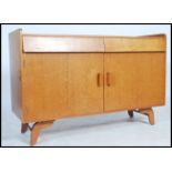 A 1970's retro teak wood sideboard dresser raised on angled legs with beehive twin single drawers