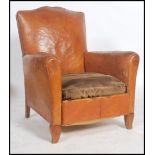 A 1930's Art Deco tan full grain leather moustache back French club armchair having barrel arms