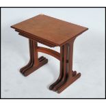 A 1970's / 20th century G-Plan teak wood nest of three inter-sliding occasional tables, raised on