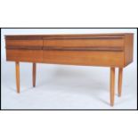 A 1960's teak four drawer sideboard comprising of two short and two long raised on shaped legs in