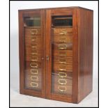 A good mid century mahogany Industrial office filing cabinet being housed behind twin glass doors