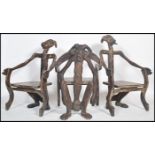 A set of 20th century African / Indonesian carved and ebonised elbow chairs comprising of a flat