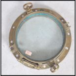 A stunning  early 20th century brass shipping porthole window with backing plate on  fitted hinge