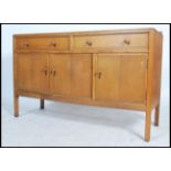 A Heal`s mid century oak sideboard, two long drawers (with Heal & Sons roundel to top drawer)