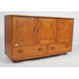 A stunning Ercol Windsor pattern low beech and elm sideboard. The low sideboard on ball castors with