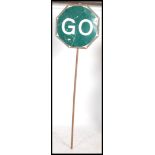 A Vintage metal 'STOP' and 'GO' sign transport interest with earlier surround having the pole