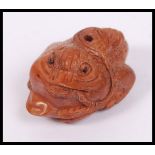 An unusual Oriental wooden carving netsuke in the form of a toad.