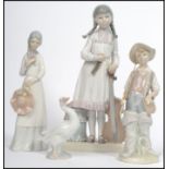 A group of three Lladro ceramic figures to include a Goose, boy with fishing rod and a girl with