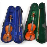 Two vintage 20th century violins complete in carry cases with bows.