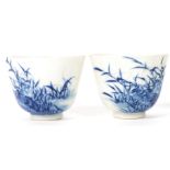 A pair of early 20th century Oriental Chinese ceramic blue and white tea cups painted with birds and