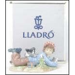 A Lladro ceramic figure titled " Study Buddies "  No. 05451 modelled as a slumbering student with