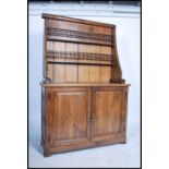 A 19th century large French country oak dresser raised on a plinth base with cupboards to base