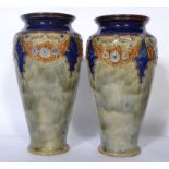 A pair of Royal Doulton early 20th century tube lined vases having tapering bodies with wasted necks