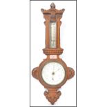 A carved oak early 20th century Aneroid banjo barometer by Dunscombe Late Braham of Bristol having