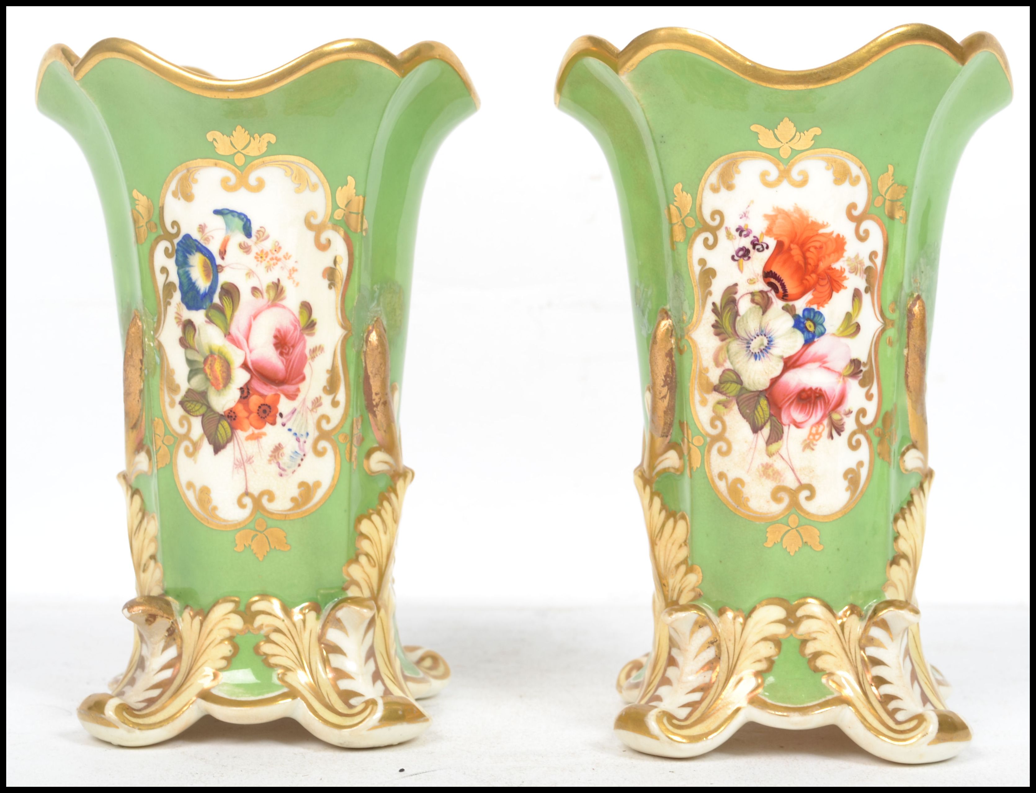 A pair of 19th century English factory vases having a green ground with white cartouche panels