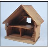 An unusual 20th century pine bird table in the form of a house having a pitched roof with interior