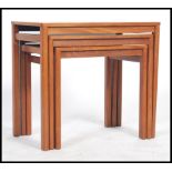 A 20th century retro teak wood nest of graduating occasional tables, each table raised on square