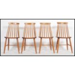 A set of 4 retro 20th century Ercol style stick back dining chairs with saddle seats raised on