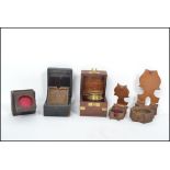 A collection of pocket watch stands to include treen examples, Victorian flip out inlaid ebonised