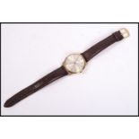 A vintage Omega gents wrist watch mounted an a brown leather strap, the silvered dial having baton