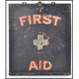 A vintage early half of the 20th century tin wall hanging First aid box, black ground with applied