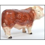 A vintage 20th century large Melba Ware ceramic figurine of a Hereford Bull being stamped to the