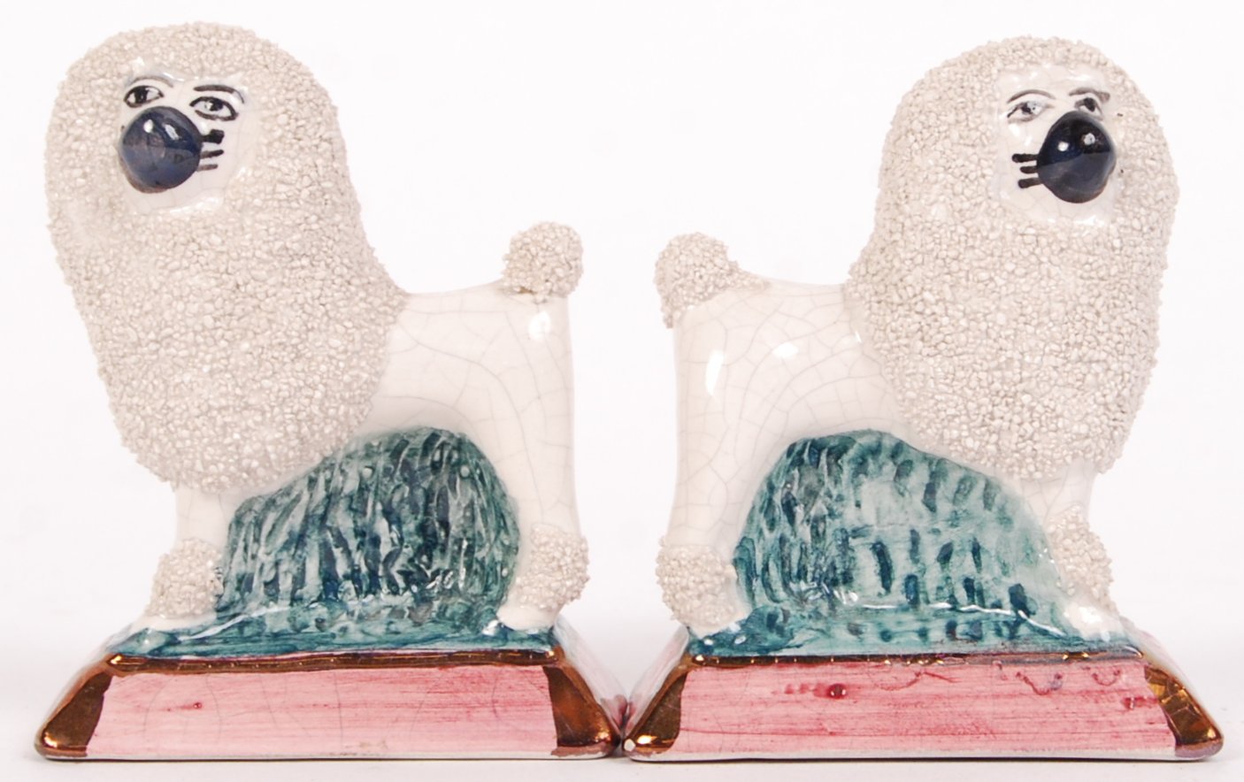 A pair of early 20th century Victorian Staffordshire porcelain miniature poodles, standing on