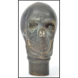 A vintage 20th century novelty gothic walking stick cane top in the form of a skull of bronze /