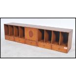 A 20th century long pigeon hole desk tidy of elongated form having central cupboard with eight holes