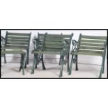 A group of four 20th century heavy cast metal garden chairs with slat seats and back rests, scroll