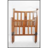 An Arts & Crafts oak head and footboard for a single bed, the central slats inlaid floral motifs