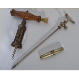 A group of three early 20th century cork screws (corkscrews) to include a tall champagne tap, a