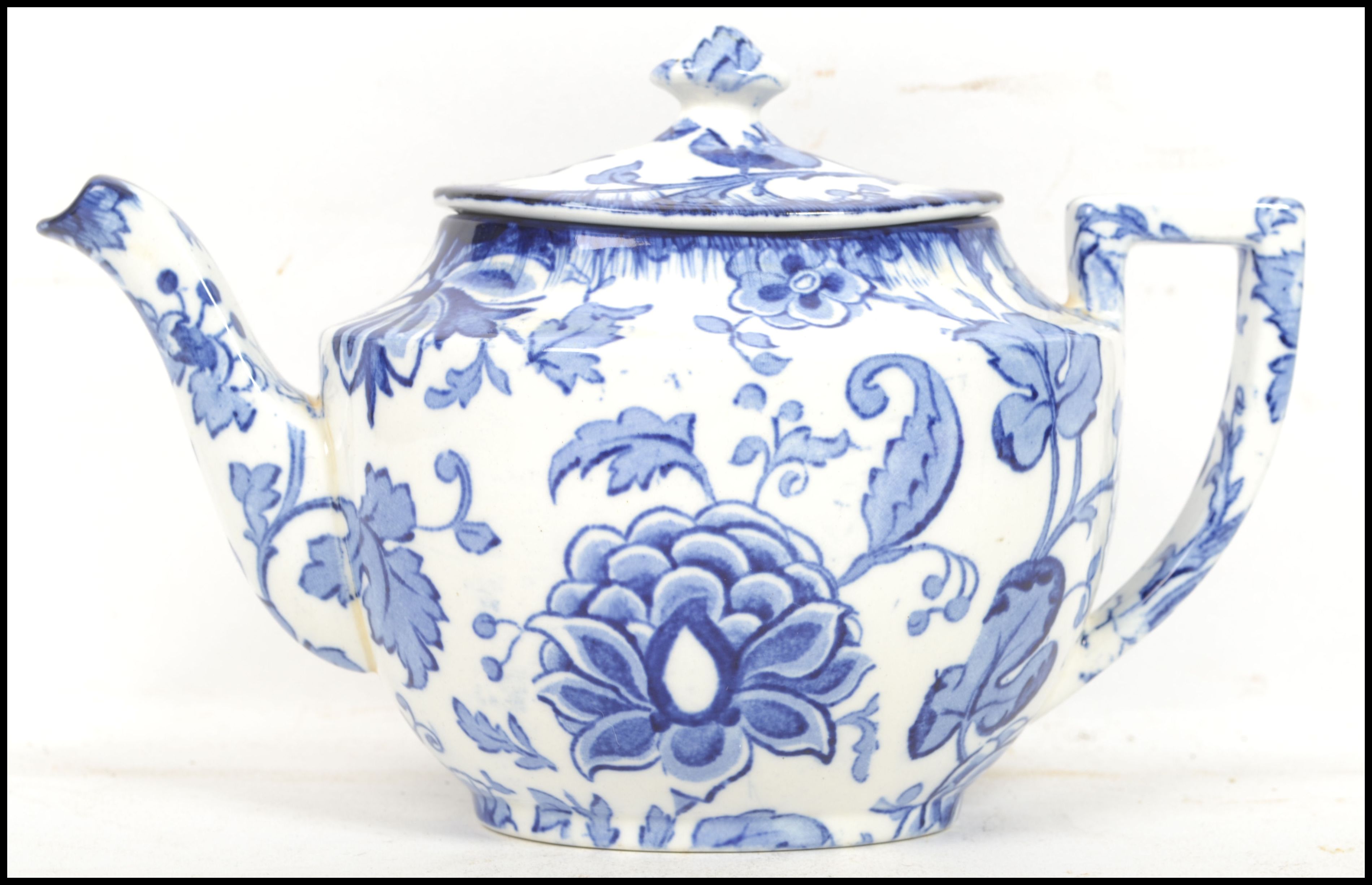 An early 20th century blue and white ceramic teapot of traditional form with shaped handle and spout