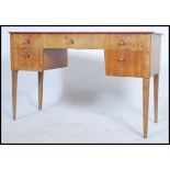 An original Gordon Russell walnut desk with an arrangement of  five drawers. All raised on tapered