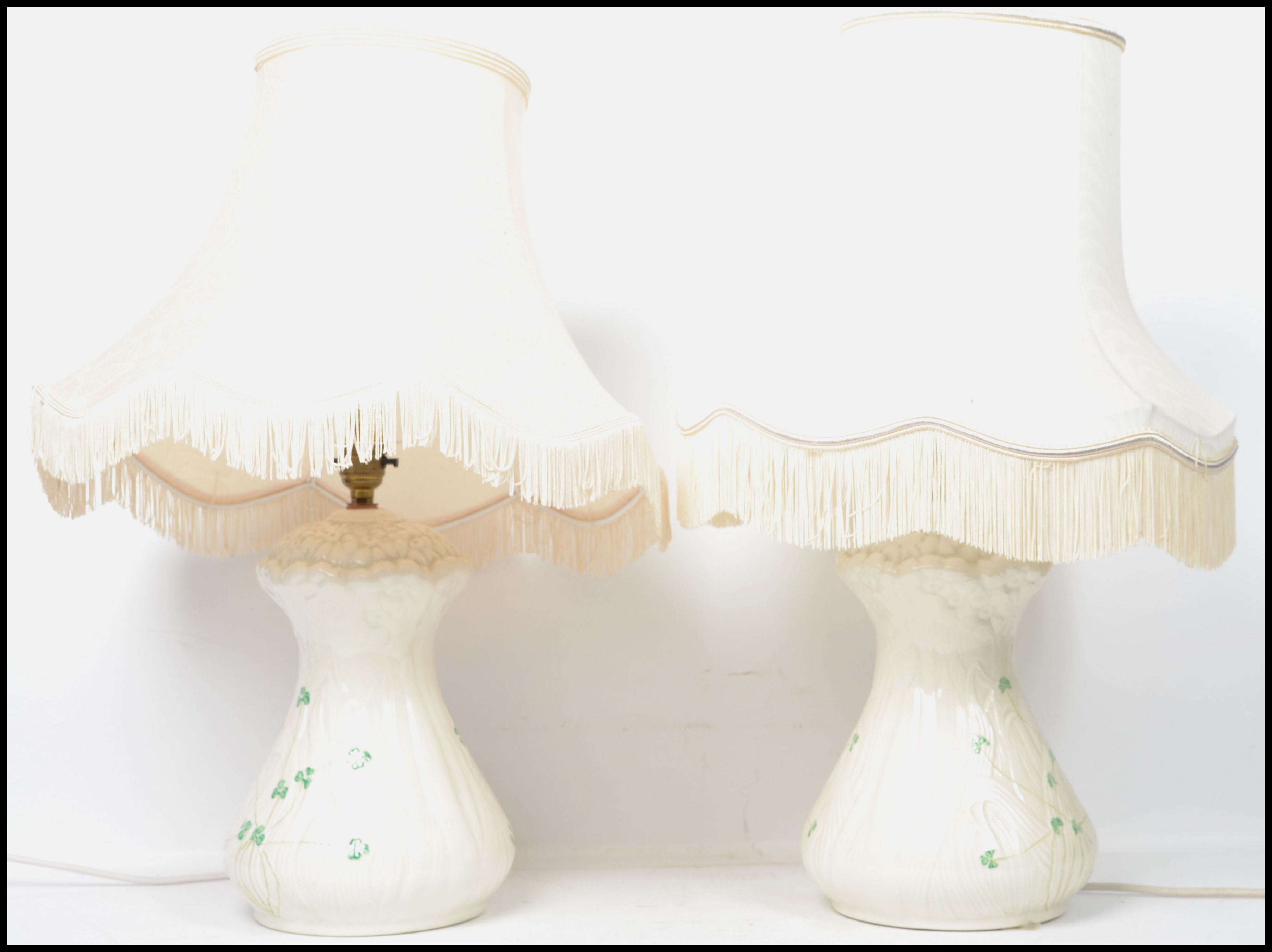 A pair of Irish 20th century Belleek ceramic table lamps decorated in the shamrock pattern, complete