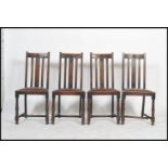 A set of 4 1930's Art Deco oak dining chairs raised on cup and cover legs united by stretchers