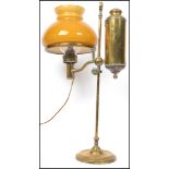 An early 20th century Argand and Co brass coaching  lamp complete with orange glass shade. Measures: