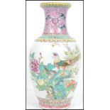 An Oriental Chinese ceramic vase having a white ground decorated with famille rose birds and flowers