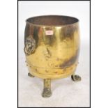 A 19th century Victorian brass coal scuttle bucket raised on three paw feet with lion mask drop