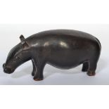 An African tribal carving of a pygmy hippopotamus of ebonised wooden construction.